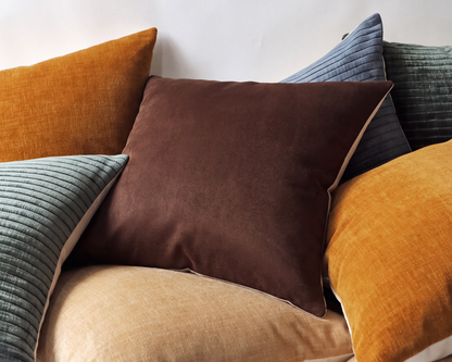 Bark brown velvet pillow cover styled with teal, orange, and tan pillows on a sofa